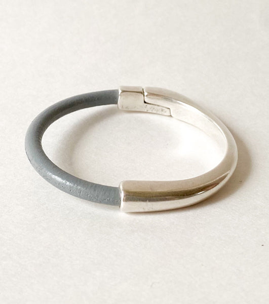 A gray leather bracelet with silver magnetic clasp