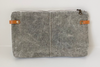 A gray waxed denim bag with leather crossbody strap or wristlet strap