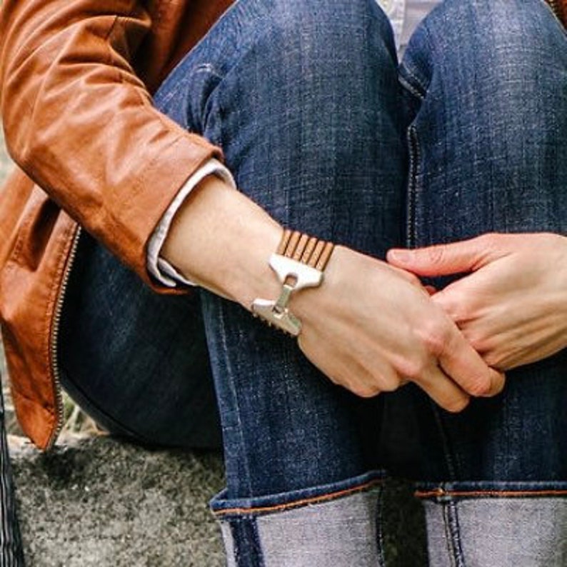 a woman wears a camel brown leather multi strand cuff bracelet with jeans and a leather jacket