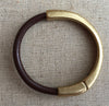 brown leather strap bracelet with antique brass magnetic clasp on burlap cloth