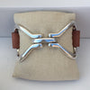 Two-Sided Snaffle Bit Leather Bracelet with Brown Leather Cuff sits on a burlap pillow