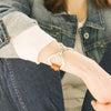 A Two-Sided Zamak snaffle bit bracelet is worn on a woman's wrist
