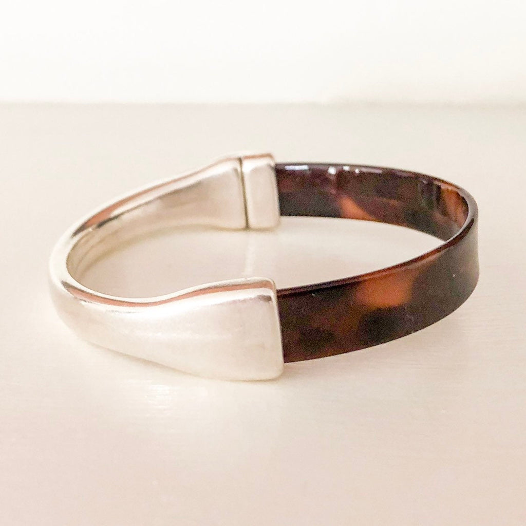 a tortoise patent leather bracelet with a silver magnetic clasp