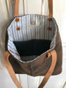 Gold Brown Plaid City Tote Felted Wool Bag with brown leather straps hangs open to show striped lining