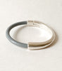 A gray leather bracelet with silver magnetic clasp