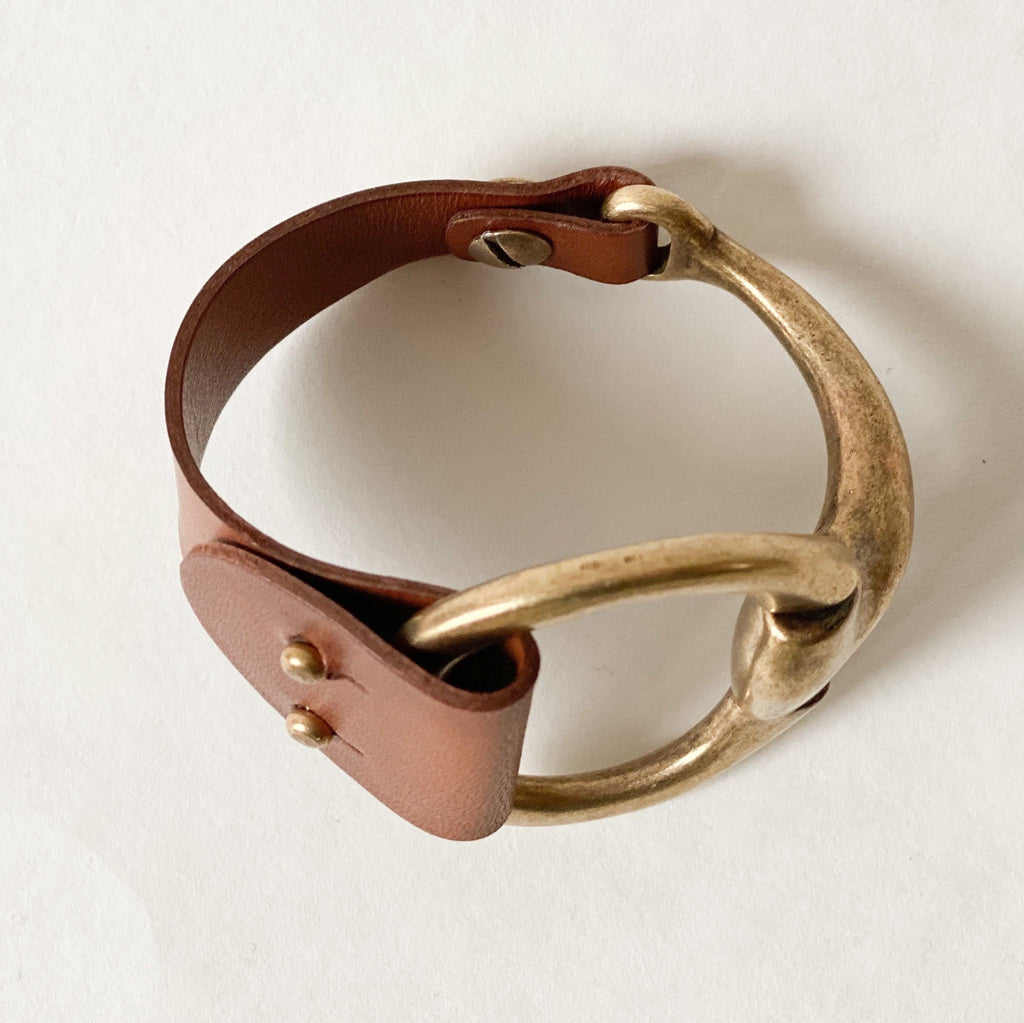 a large snaffle bit bracelet with brown leather and antique brass clasp