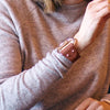 a woman wears a large brown leather and Zamak snaffle bit bracelet on her wrist