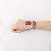 a woman wears a brown leather and Zamak snaffle bit bracelet alongside a small snaffle bit bracelet