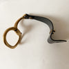 Large Antique Brass Snaffle Bit Bracelet with Black Leather is shown unclasped on a white table