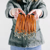 A woman holds a collection of genuine leather wristlet straps for a crossbody pouch bag