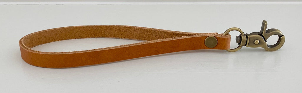 a brown leather wristlet strap for a crossbody pouch bag