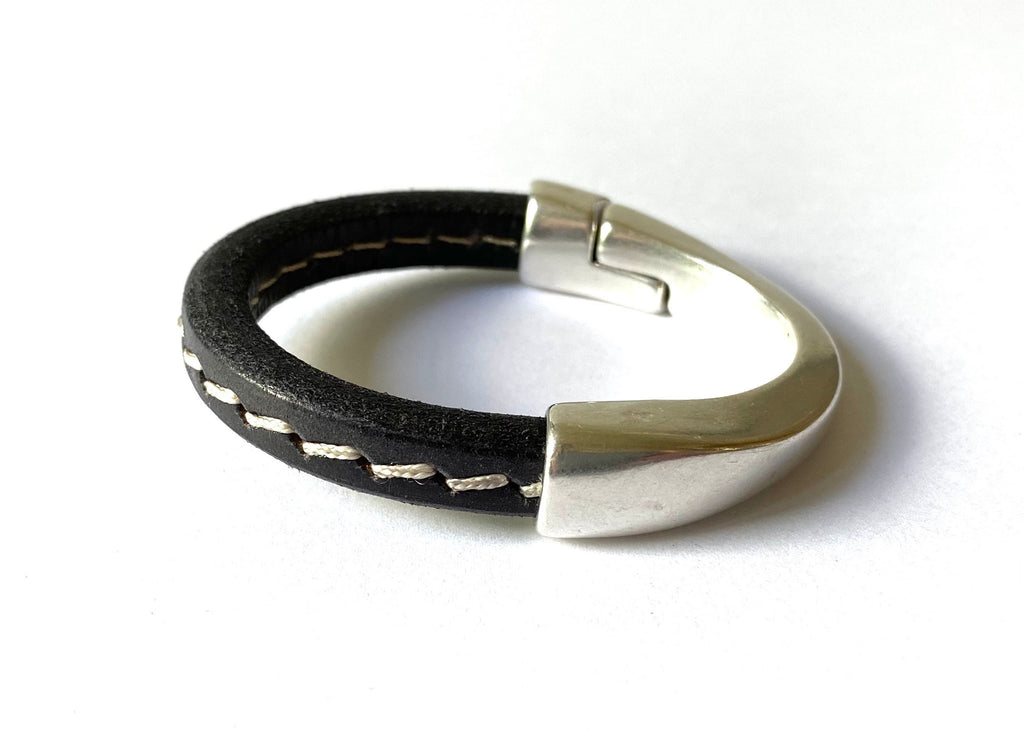 black leather bracelet with silver clasp and white stitching
